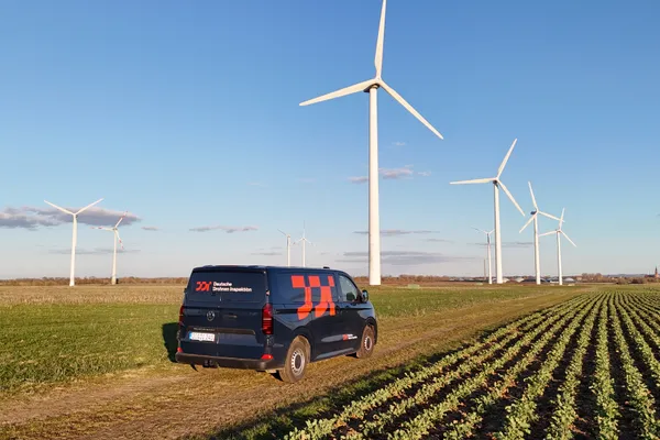 DDI Bulli mit Branding im Windpark vor Windkraftanlagen