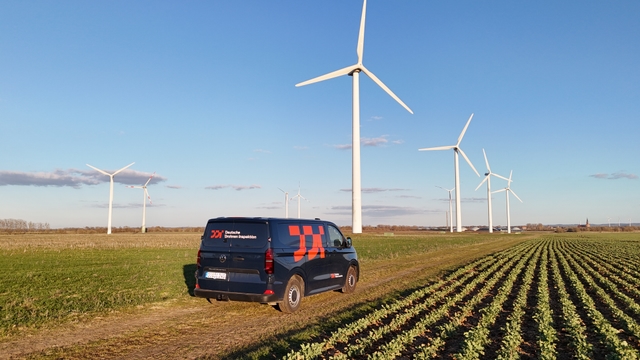 DDI Bulli mit Branding im Windpark vor Windkraftanlagen